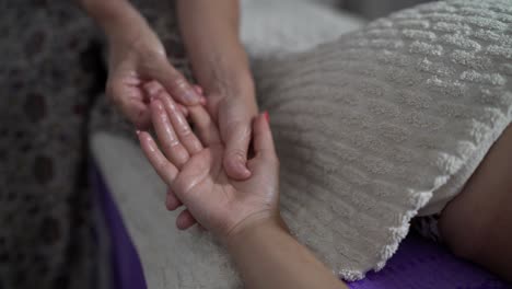 masseuse kneading elbow of lying patient