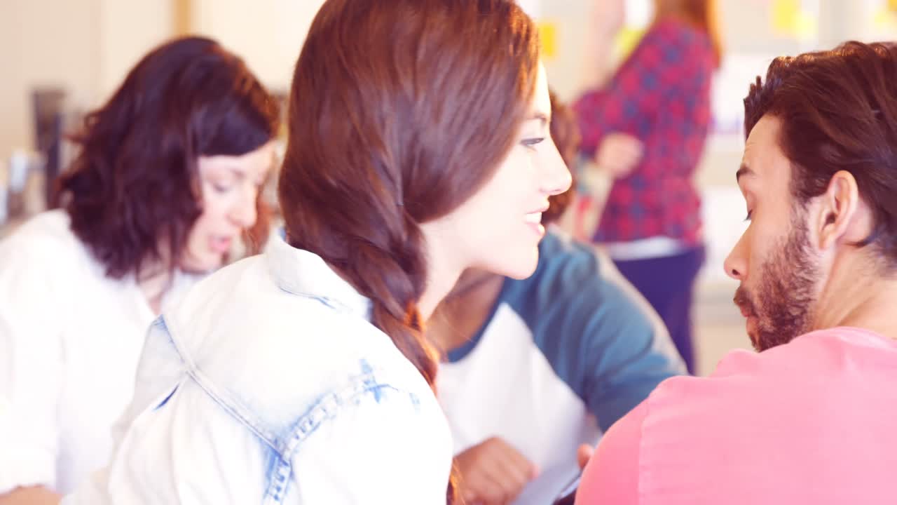 여성 경영자가 회의에서 동료에게 무언가를 속삭이고 있습니다.