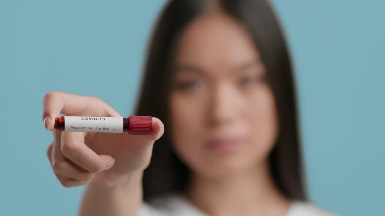 Donna che tiene una provetta per il test sanguigno del COVID-19