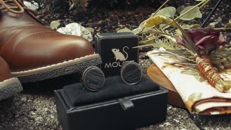 close up shot of groom accessories like shoe cufflinks and rose