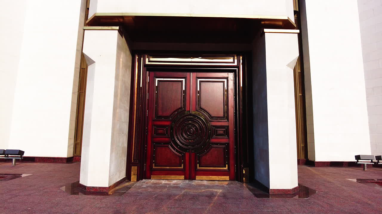 Chisinau, Moldova - December 23, 2021: A stunning wooden door stands at the entrance of a historical building. The door features detailed carvings and a remarkable finish, inviting visitors to explore the architectural beauty inside