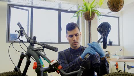 hombre reparando una bicicleta en el taller 4k