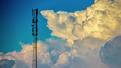 telecommunications tower with cumulus clouds in blue sky