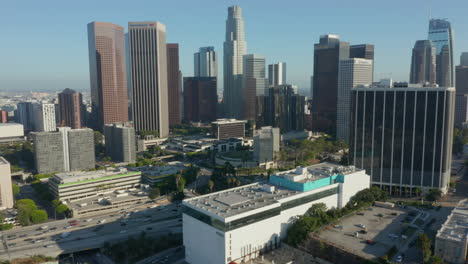 Slow-tilt-up-revealing-huge-city-skyline-with-multiple-Towers-and-Office-Buildings,-Aerial-Dolly-in