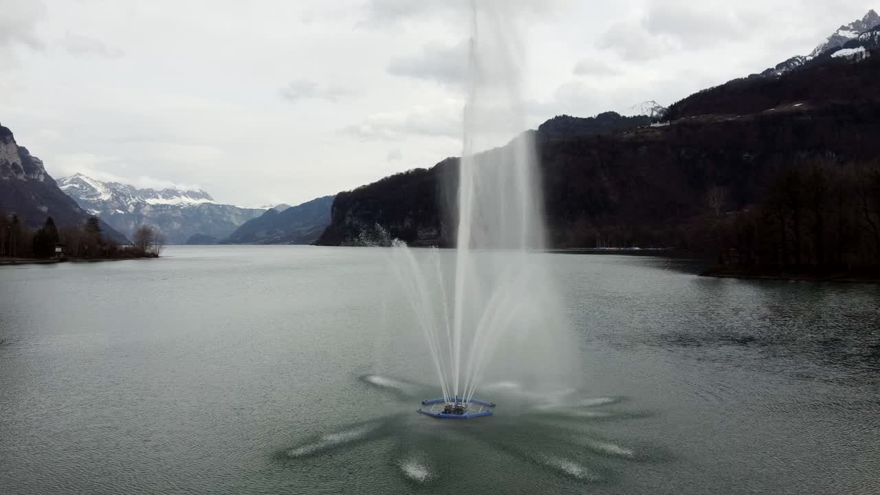 Drone hovering over the fountain in the lake Walensee in Weesen in the canton of St. Gallen, Switzerland.