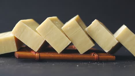 stacked beige handmade soap bars on wooden mat