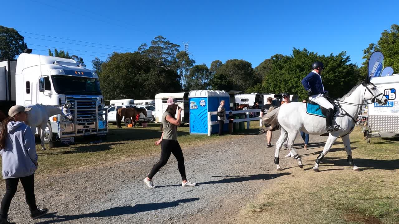 People and horses preparing for an equestrian event