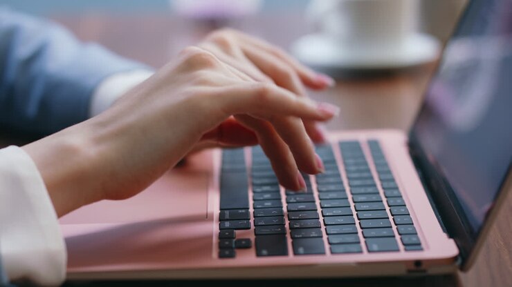 Nahaufnahme: Hände einer Geschäftsfrau tippen im Büro auf der Laptoptastatur. Eine Frau tippt.