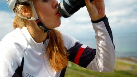 mujer ciclista bebiendo agua en un camino rural 4k