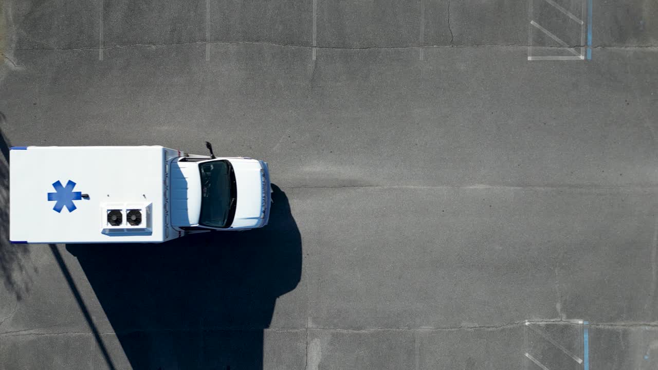 왼쪽에서 오른쪽으로 주차장을 통해 운전하는 오버헤드 뷰 구급차