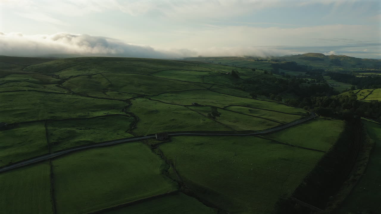 estableciendo un avión no tripulado disparado sobre las colinas de yorkshire dales en una mañana nublada