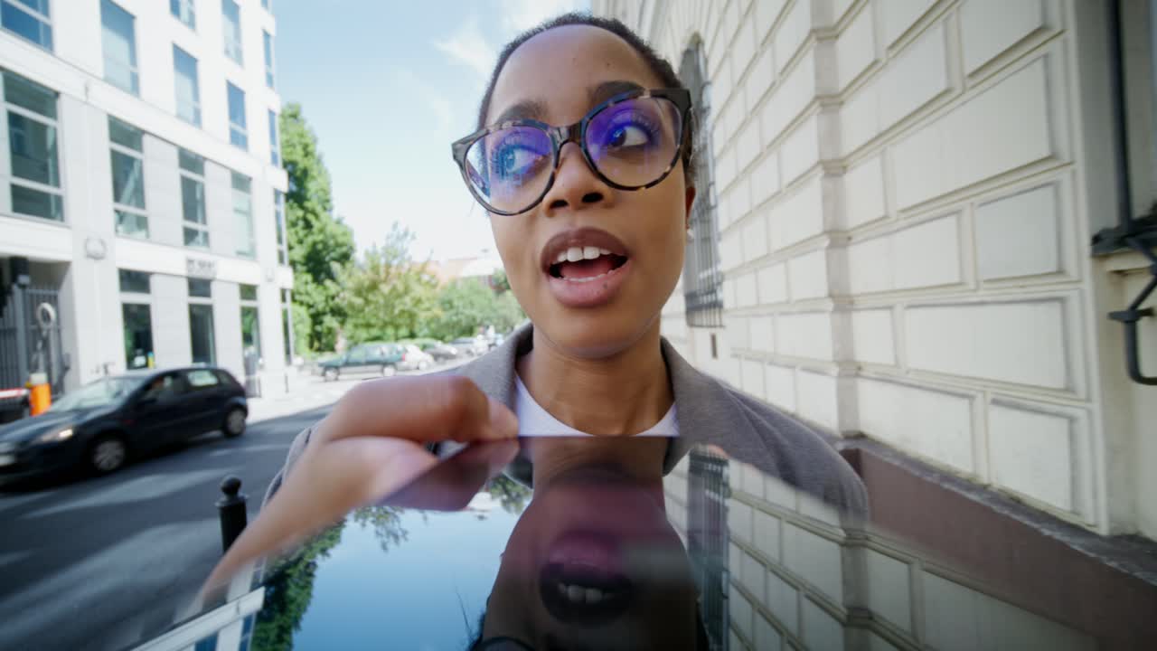 mujer interactuando con una tableta en una calle de la ciudad