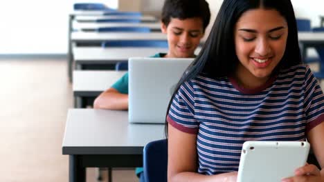 escolar y escolar usando portátil y tableta digital mientras estudian en el aula