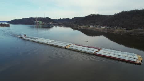 Approaching-Lansing-Iowa,-a-towboat-pushing-barges-north-on-the-Mississippi-River-1