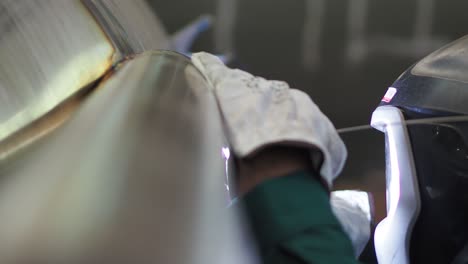 close-up of a welder repairing a car