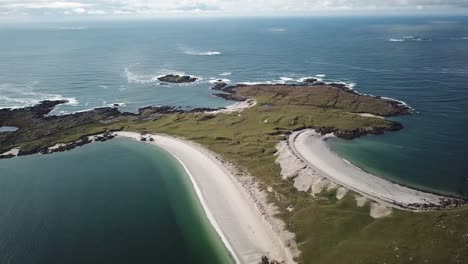 aerial view of clifden beach in connemara, blue water, sand, and grassy fields