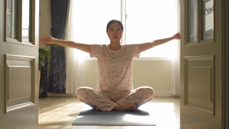 a serene morning meditation: capturing the tranquility of a young woman in pajamas as she engages in mindfulness practice in a sunlit room