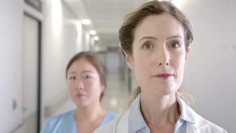 portrait of diverse female doctors standing in hospital corridor, selective focus, slow motion