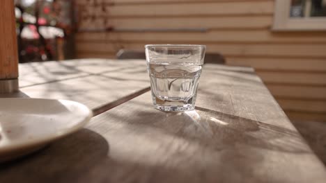 glass of water on table, zooming in slowly