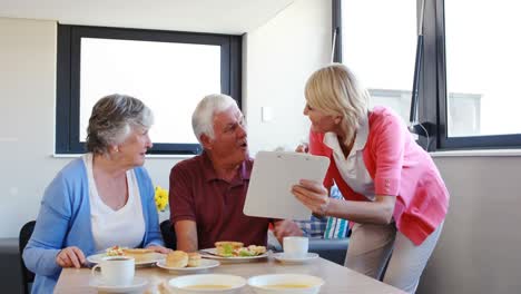 Dietician-assisting-breakfast-to-senior-couple