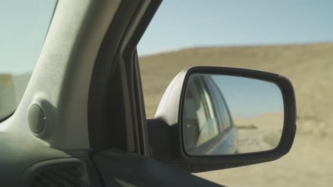 Espejo-Lateral-De-Un-Coche-Conduciendo-Por-El-Desierto-Caliente