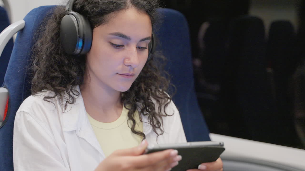 mujer joven viajando con auriculares y tableta