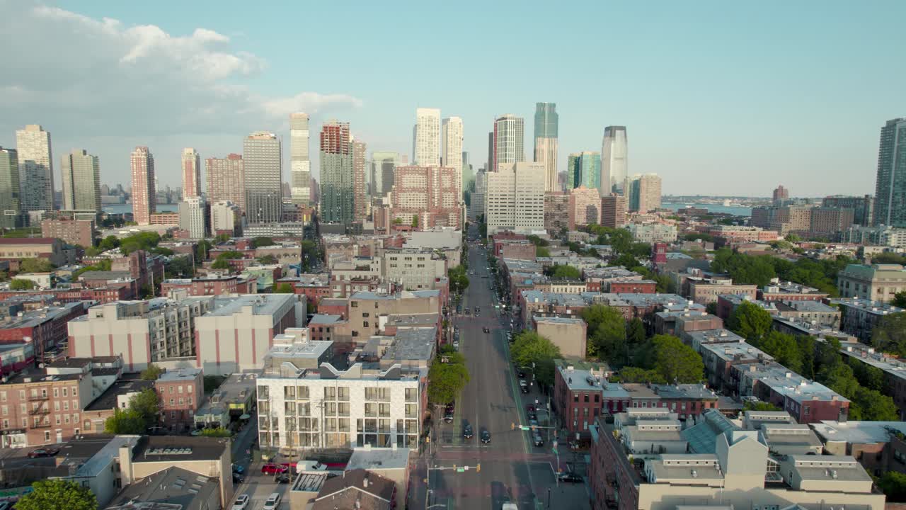 Sweeping drone footage of a city skyline under a clear blue sky