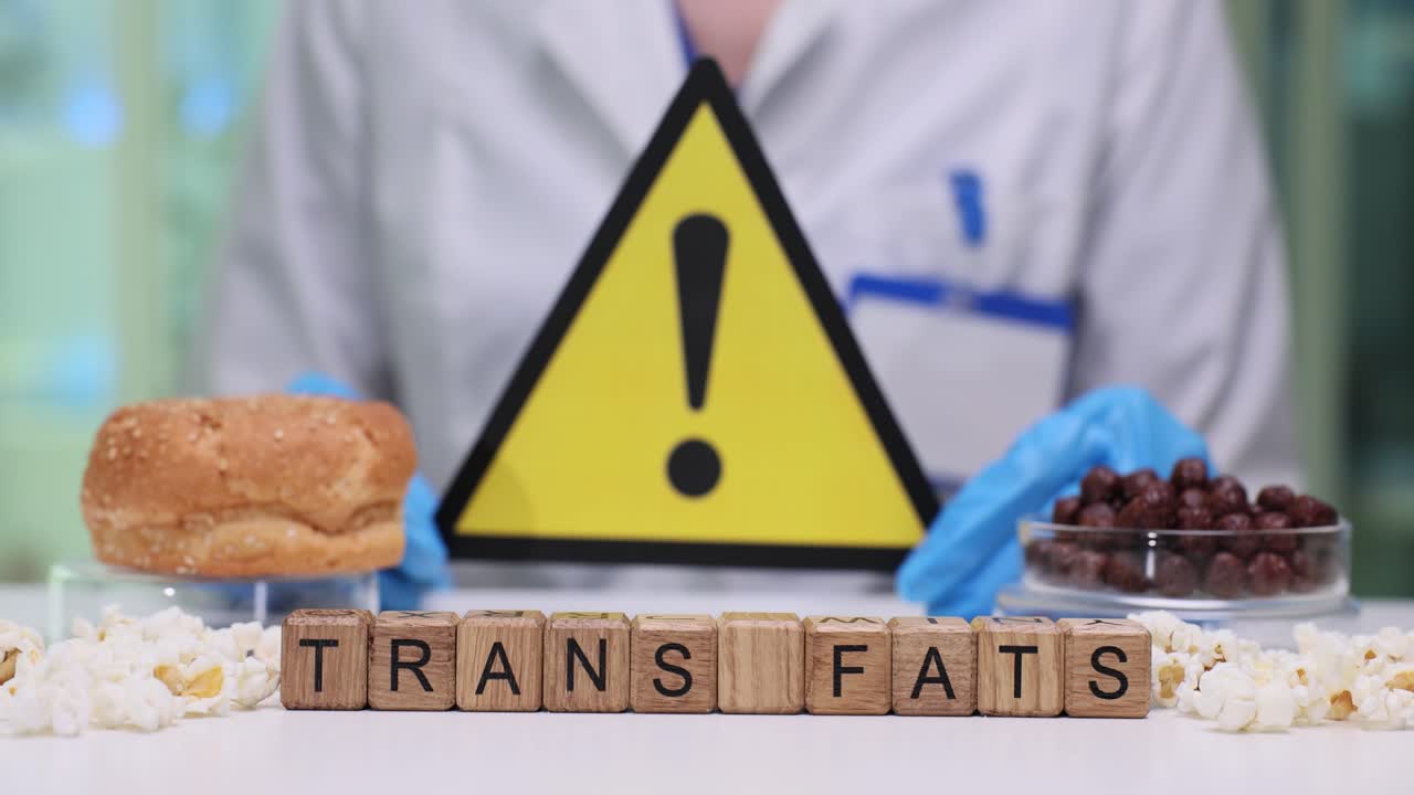 Scienziato che tiene un cartello di avvertimento sui grassi trans e alimenti non salutari