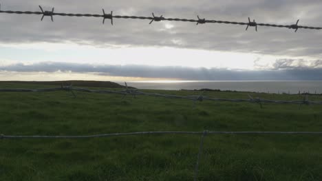 barbed wire fence at the seaside on a cloudy day