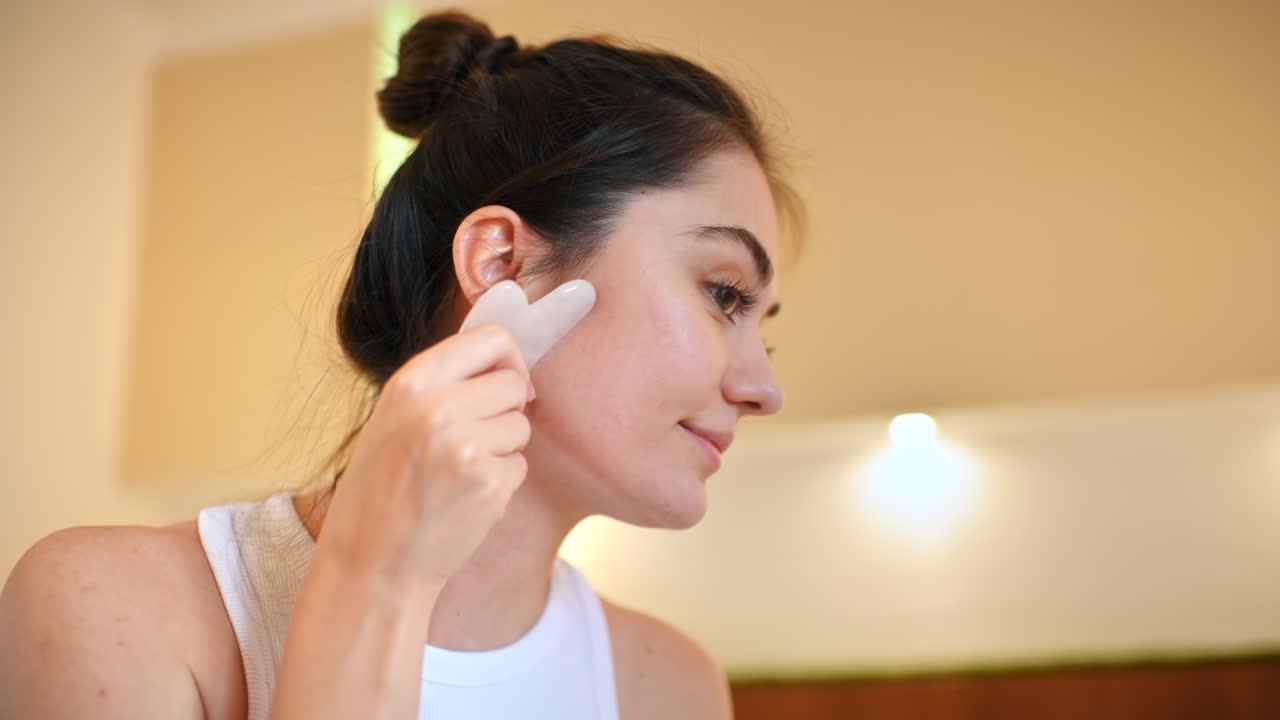 Donna che usa il Gua Sha per la cura della pelle