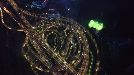 Toma-Aérea-De-Carreteras-Circulares-Y-Autopistas-Que-Flotan-En-El-Intercambio-De-Cinco-Niveles-En-Chongqing-Y-Automóviles-Que-Circulan-Por-Ellas-En-La-Noche