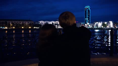 Couple Watching City Lights by the River at Night