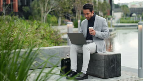 businessman working on laptop in city park
