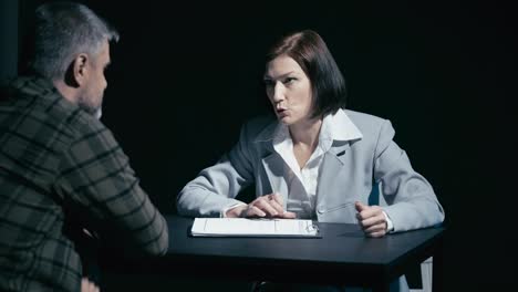 Male rejecting evidence in police, female detective putting pressure on suspect