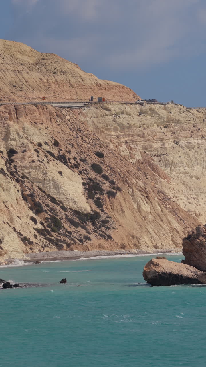 Aerial drone view of Aphrodite's Rock near Paphos, Cyprus, surrounded by turquoise Mediterranean waters. Vertical