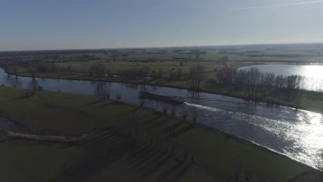 Langsam-Bewegte-Drohnenaufnahme-Eines-Frachtschiffs,-Das-Den-Fluss-Hinunterfährt