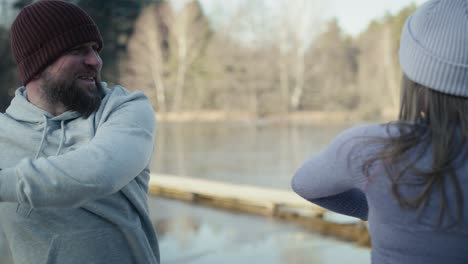 Erwachsenes-Kaukasisches-Paar,-Das-Sich-Vor-Dem-Winterschwimmen-Aufwärmt.