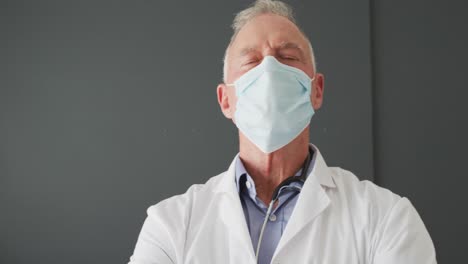 Portrait-of-caucasian-senior-male-doctor-wearing-face-mask