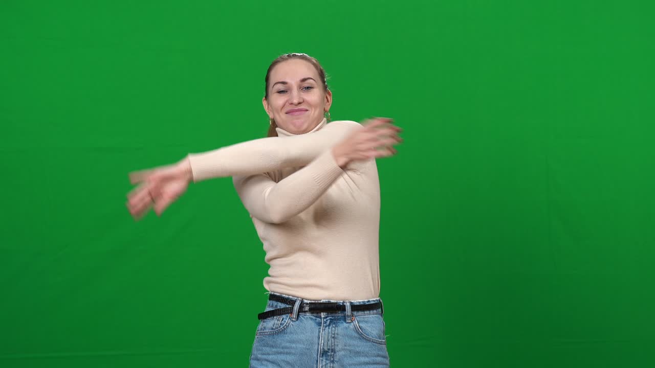 mujer divertida y alegre bailando en la pantalla verde sonriendo. retrato de una mujer caucásica positiva y relajada disfrutando de la música bailando en el fondo de chromakey. concepto de diversión y ocio