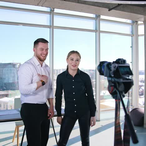 young couple shooting video about their business. beautiful woman and handsome guy standing in front of professional camera and talking for video in the studio