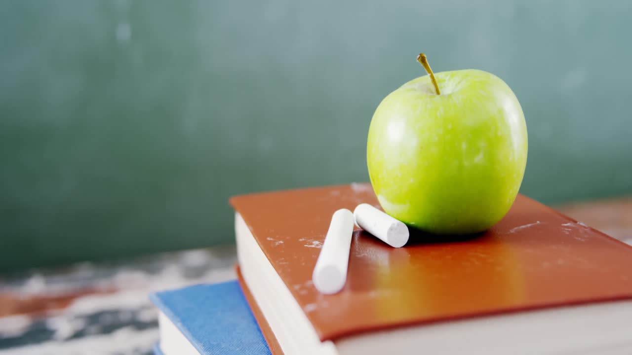 manzana y tiza en la pila de libros