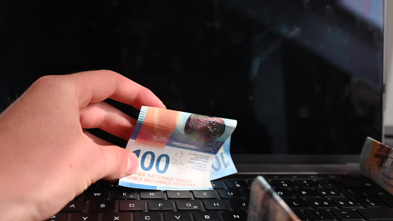 un usuario de computadora muestra billetes de 100 dólares