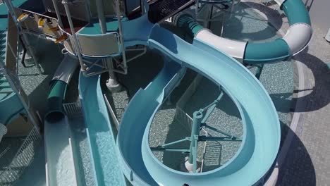 aerial view of a little girl having fun sliding down a waterslide at a waterpark in the summer