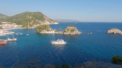 ferryboat docking at marina, small rocky islets in deep blue sea, greek coastline