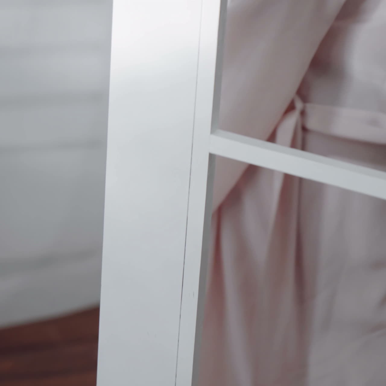 Woman in a light-colored dress, posing by a window