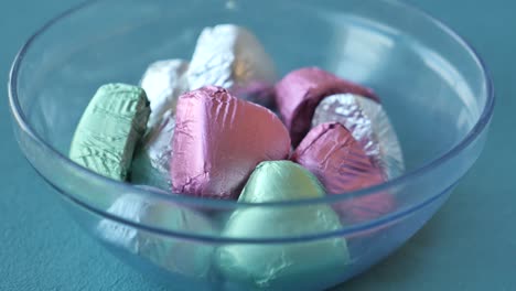 colorful foil-wrapped chocolates in a glass bowl