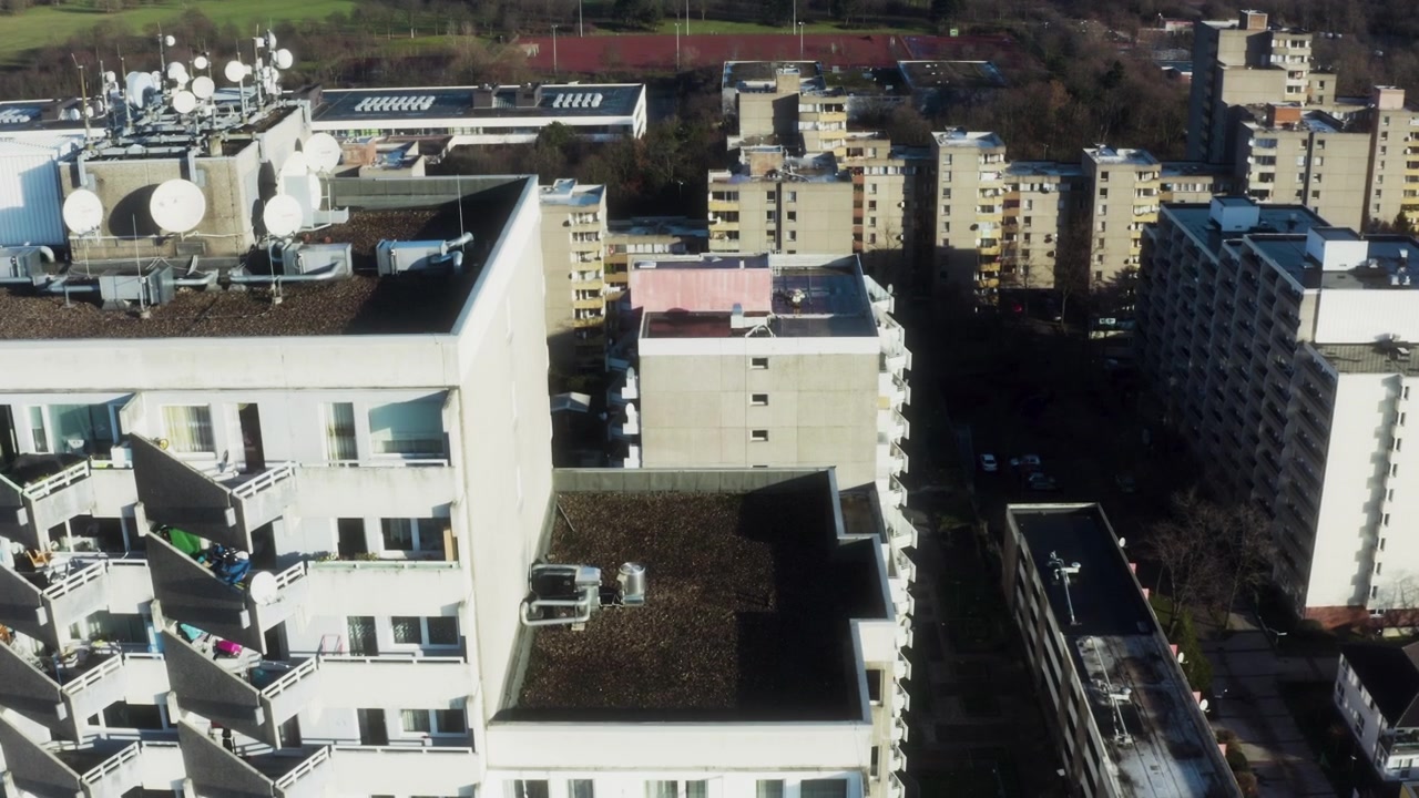 Parabolantenner dækker et tag i Köln, mens en drone flyver over kvarteret