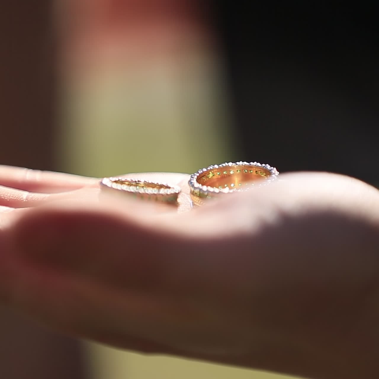 The groom holds gold wedding rings on the palm. Wedding concept.