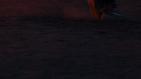 man who dances a moonwalk against the background of a burning car