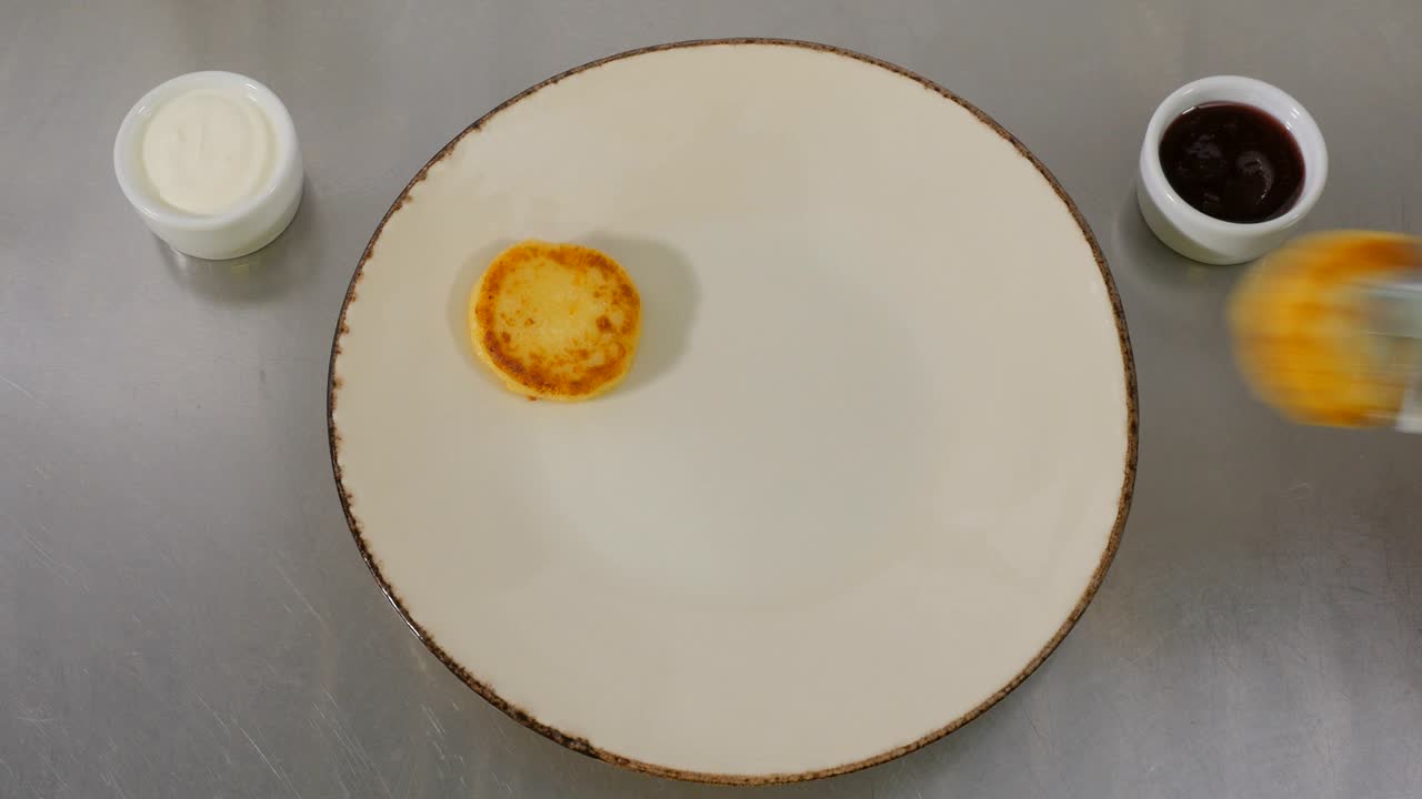 el cocinero puso los panqueques de queso en un gran plato blanco